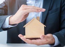 businessman-hand-cover-wooden-home-model-real-est-2022-11-07-23-19-27.jpg